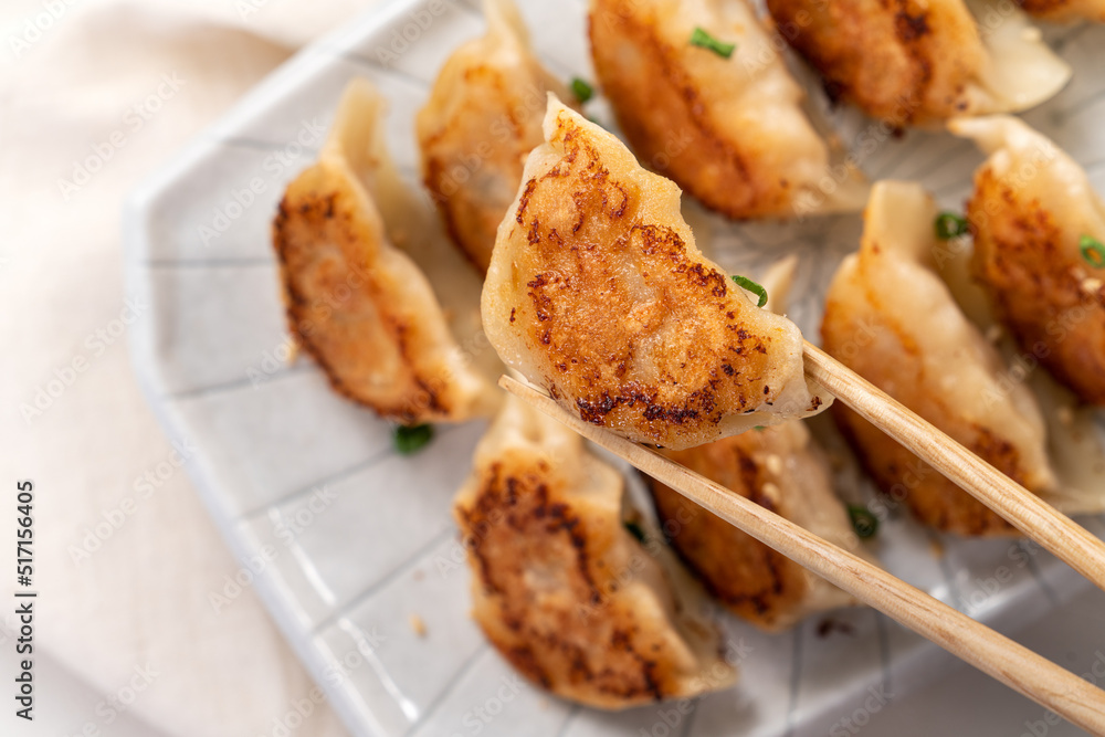 用酱油在白色桌子背景上的盘子里煎饺子饺子饺子。