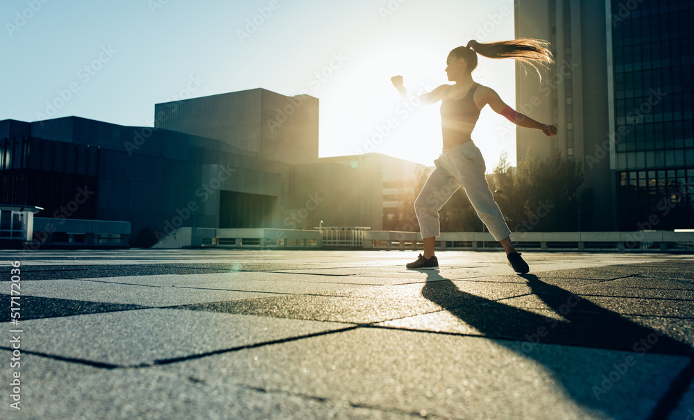 Female athlete doing tricking practice outdoors in the city