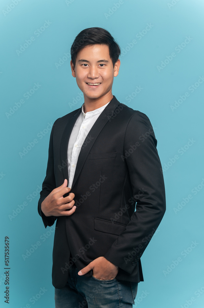 Young asian man in suit and jeans for smart casual business concept isolated on blue background