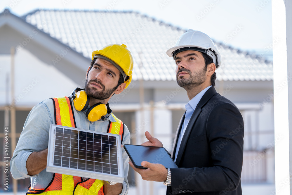 工程师和商人正在检查太阳能电池板，为安装在新家Renewab做准备