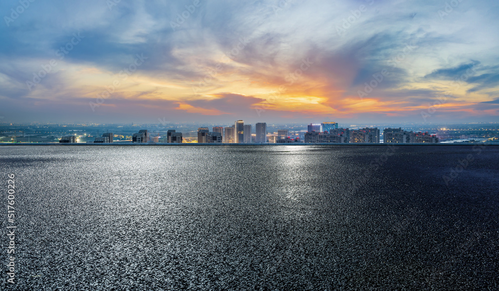 沥青路和现代城市天际线，夜晚有建筑景观。高角度视野。