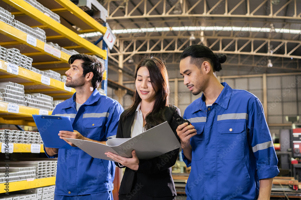 Caucasian industrial male worker and businesswoman working in factory. 