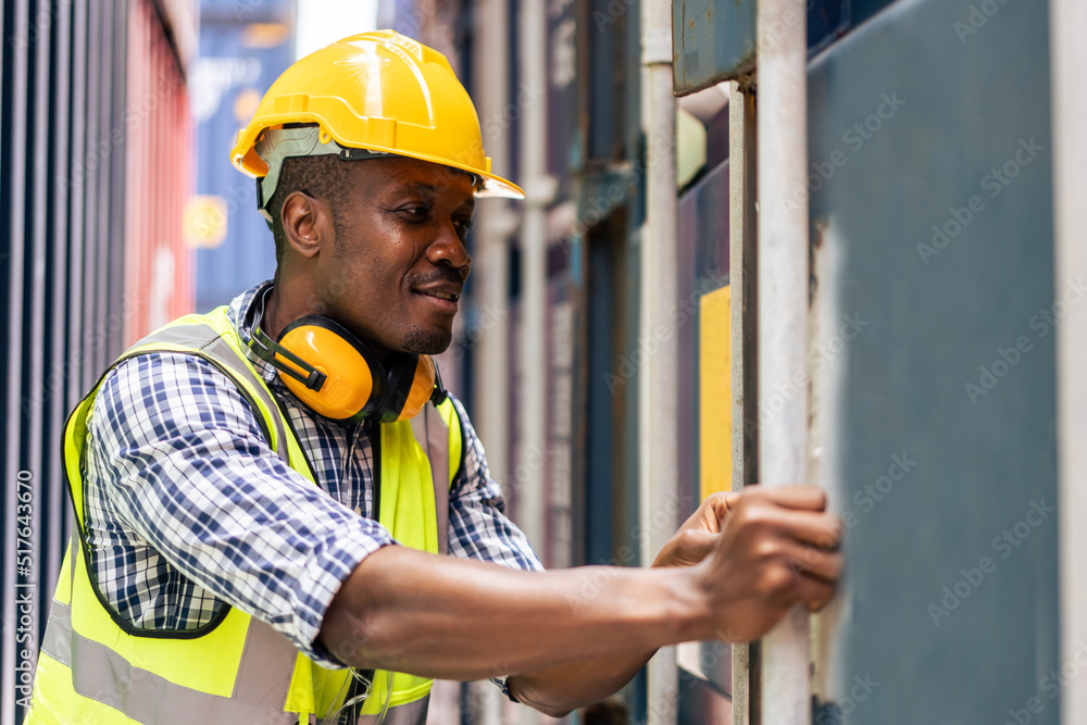 Young African engineer man worker working in container port terminal.