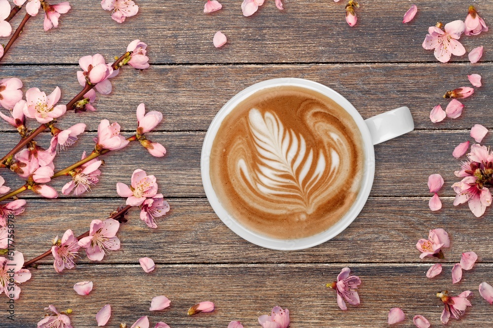 Spring composition with coffee and blooming flowers on the desk