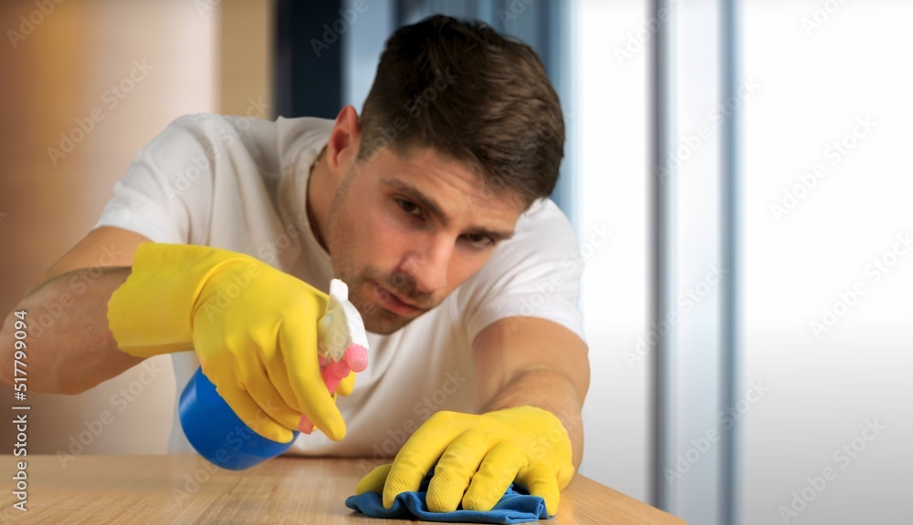 Weekend homework. Cleaning the kitchen at home. Hands in yellow gloves cleaning the countertop, work