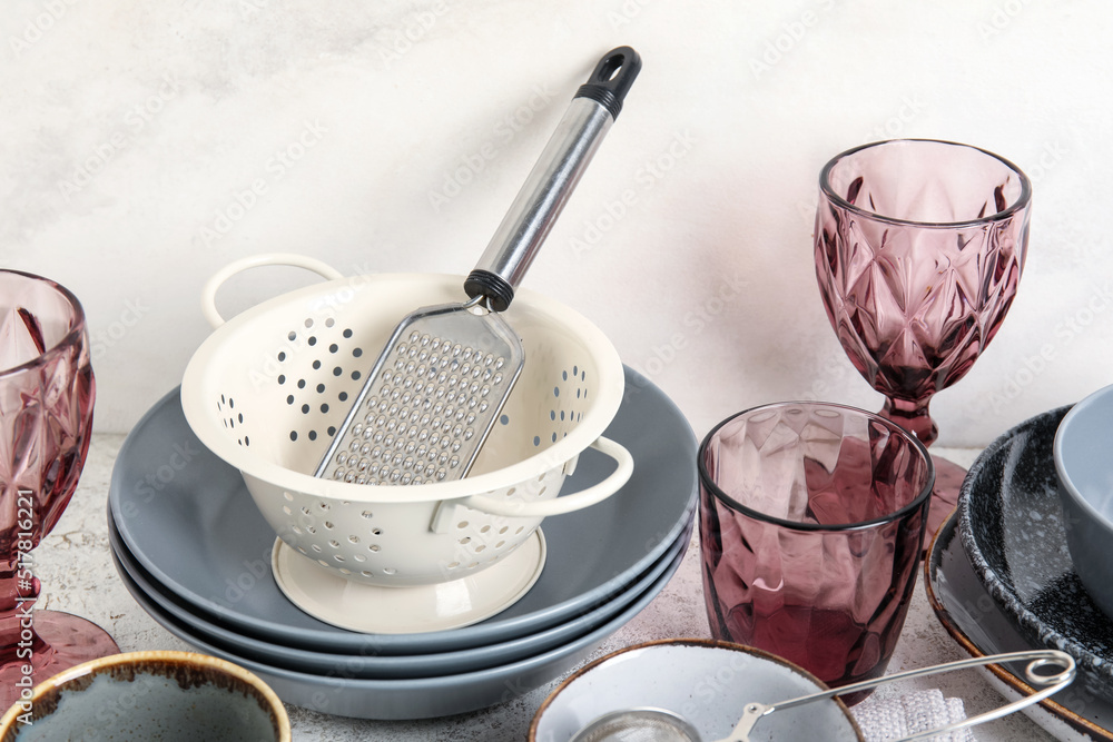 Set of clean dinnerware and kitchen utensils on light background, closeup