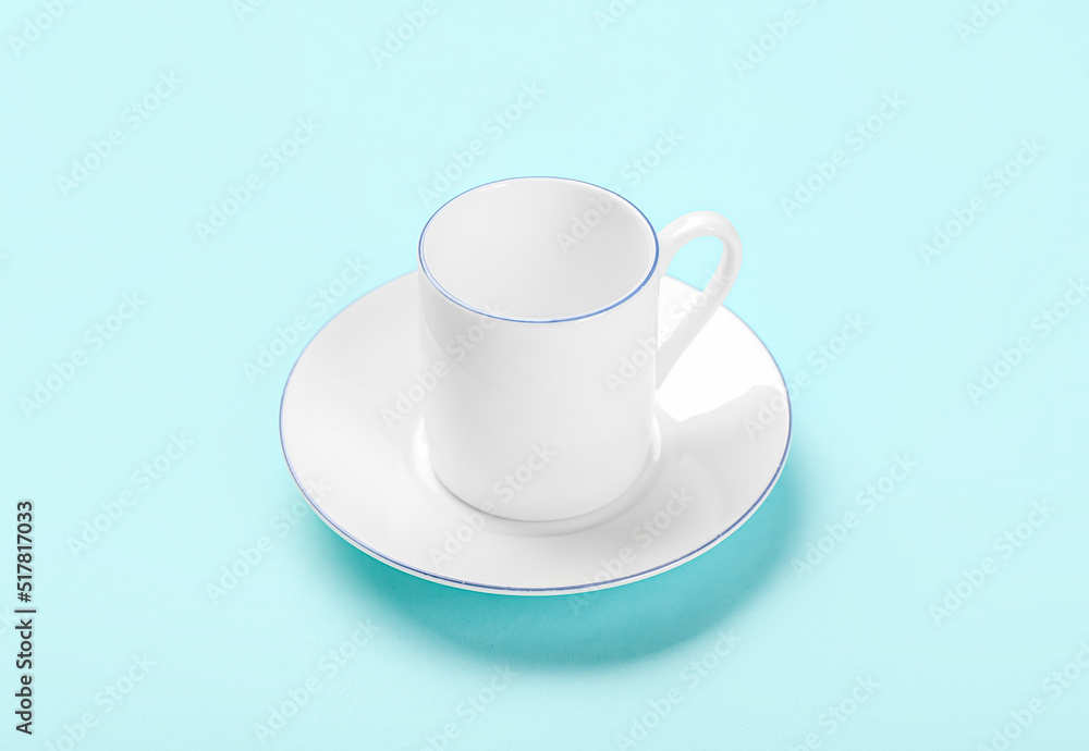 Cup for coffee with saucer on color background