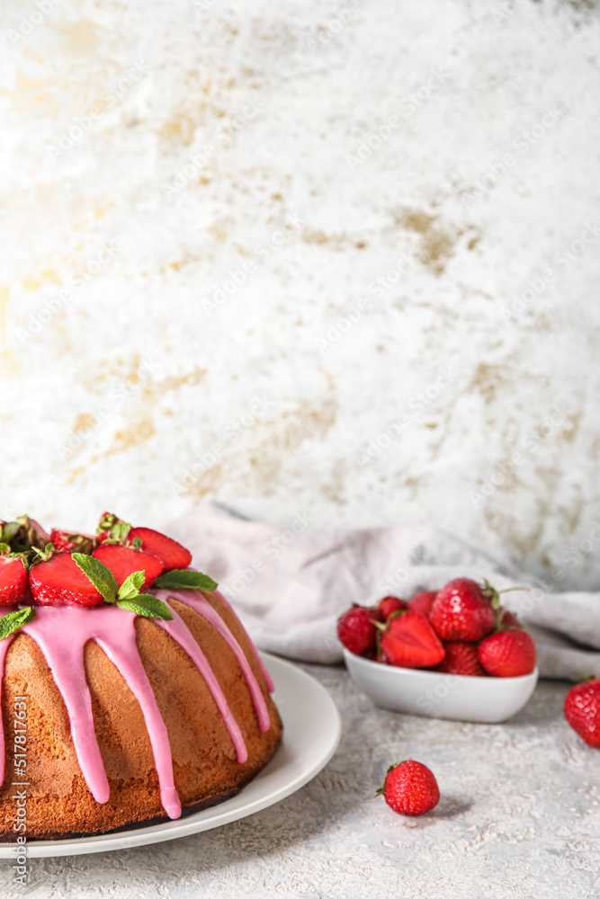 Plate with delicious strawberry cake on light background