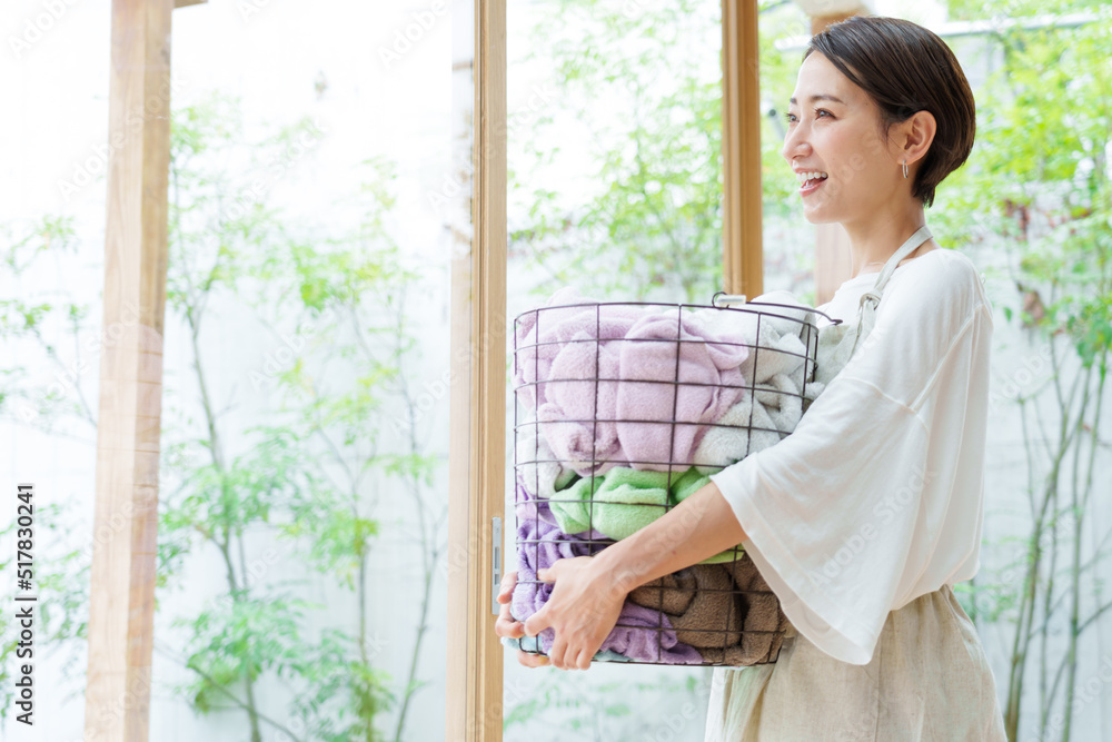 洗濯かごを持つ若い女性