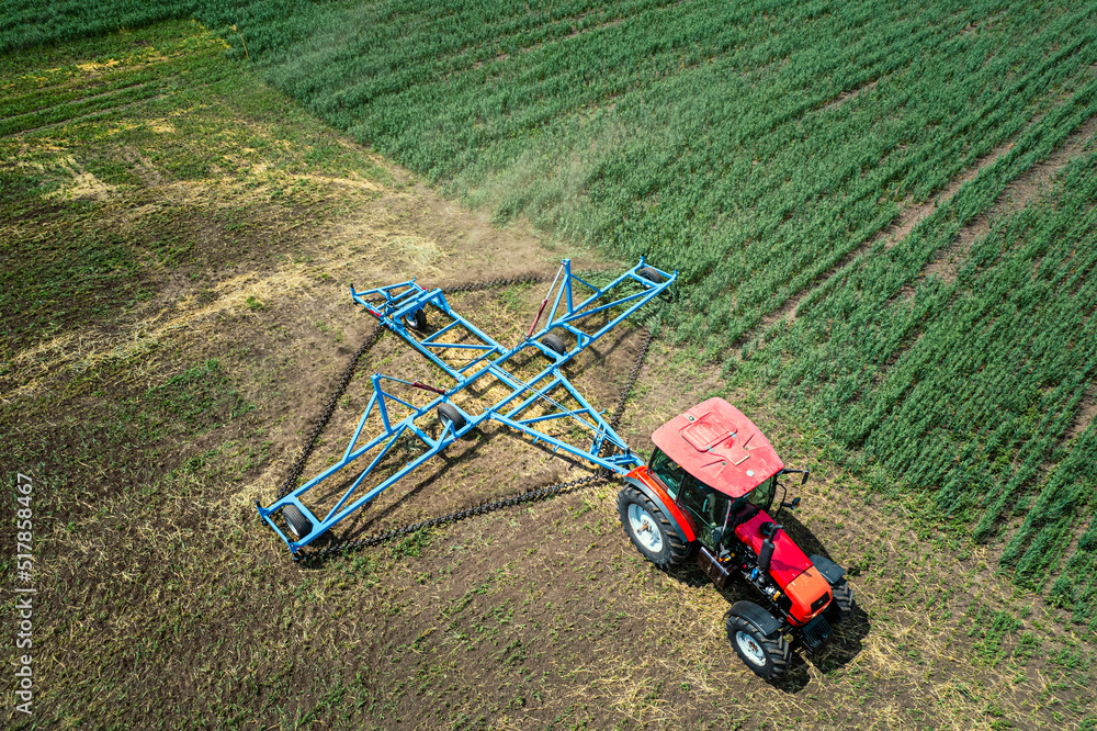 Aerial view of tractor spraying the chemicals on the large green field