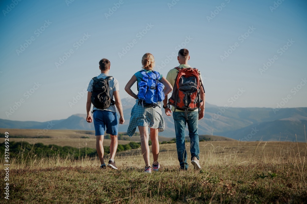 A group of tourists with backpacks are walking in mount