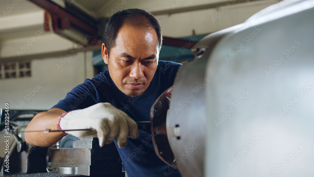 Technician asia worker using vernier caliper measure detail of workpiece for checking size in worksh