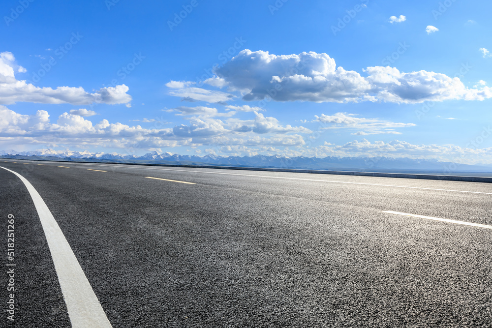 蓝天下的沥青公路和山脉。空旷的道路和山脉的自然背景。