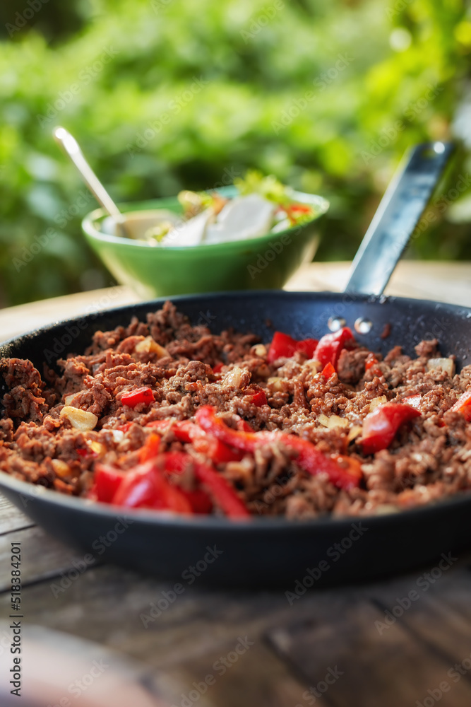 Close up view of hot juicy ground beef stewed with tomato sauce, spices, basil and finely chopped ve