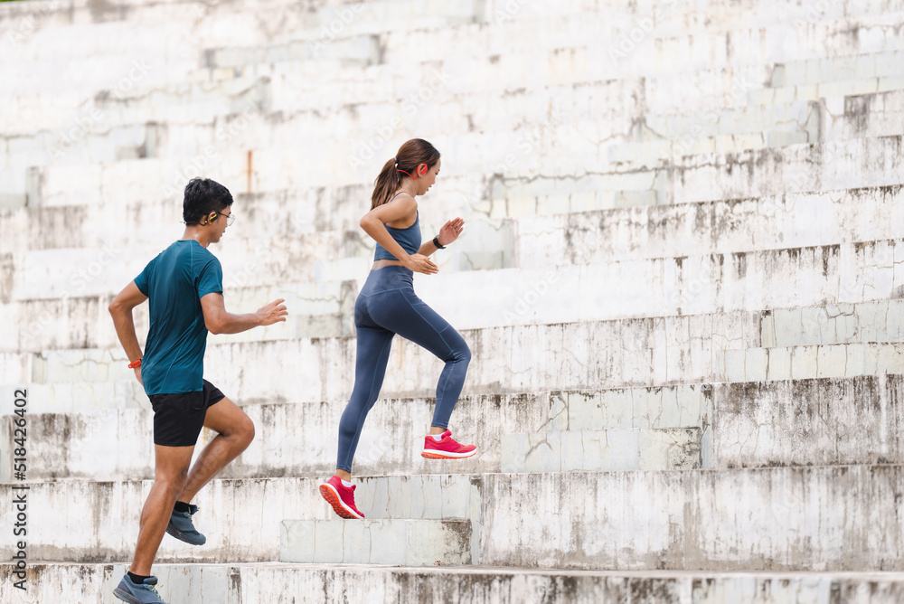 A couple of Asians are exercising and jogging up the stairs.