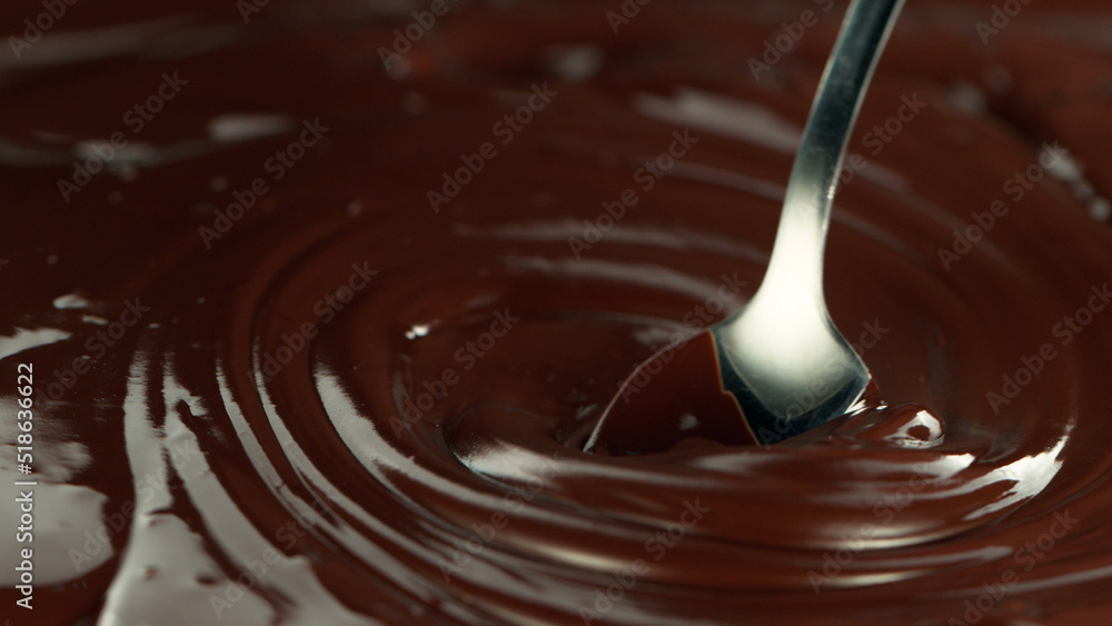 Close-up of stirring stream of melted chocolate.