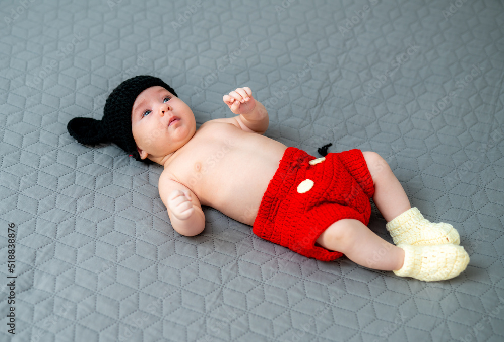 Adorable cute baby lying in mickey mouse costume. First birthday.