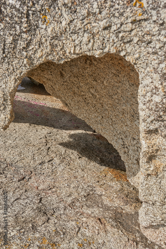 Closeup of rough rock with deep cracks, holes and crevices from wind, heat or water erosion from glo