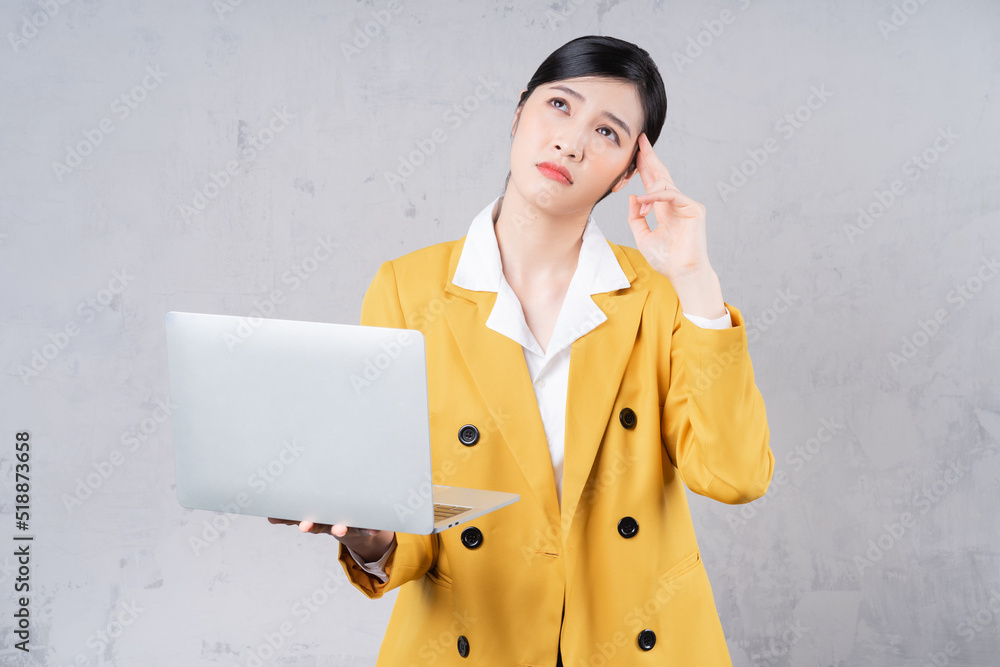 Photo of young Asian woman holding laptop