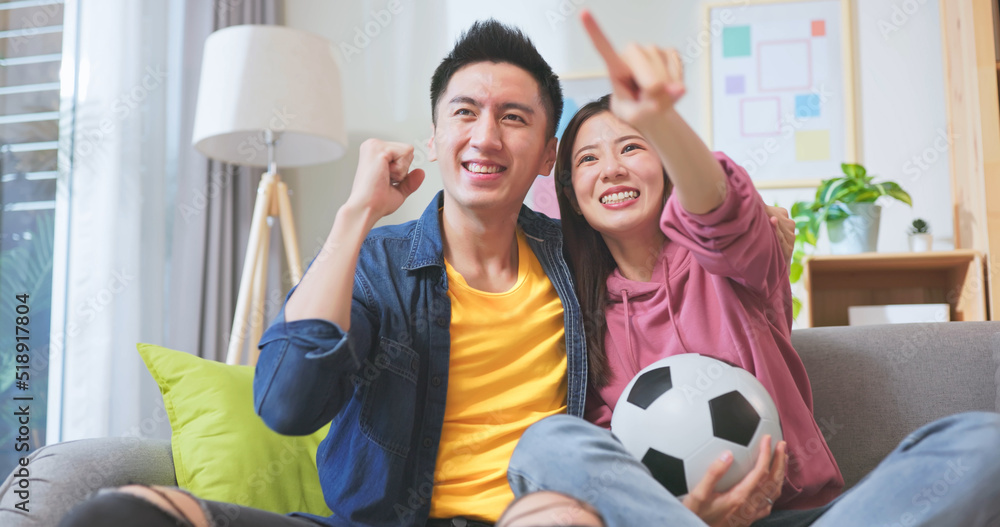 asian couple watching soccer game