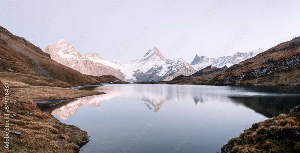 Bachalpsee lake in Swiss Alps mountains. Snowy peaks of Wetterhorn, Mittelhorn and Rosenhorn on back