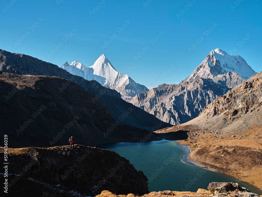 亚洲徒步旅行者在中国稻城亚丁观看詹帕扬山、恰纳多耶和博雍错湖