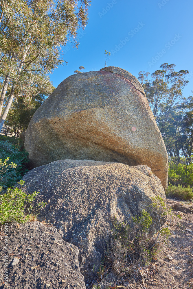 Blue sky, weathered rock and cracked stone from heat exposure and wind erosion along a countryside d