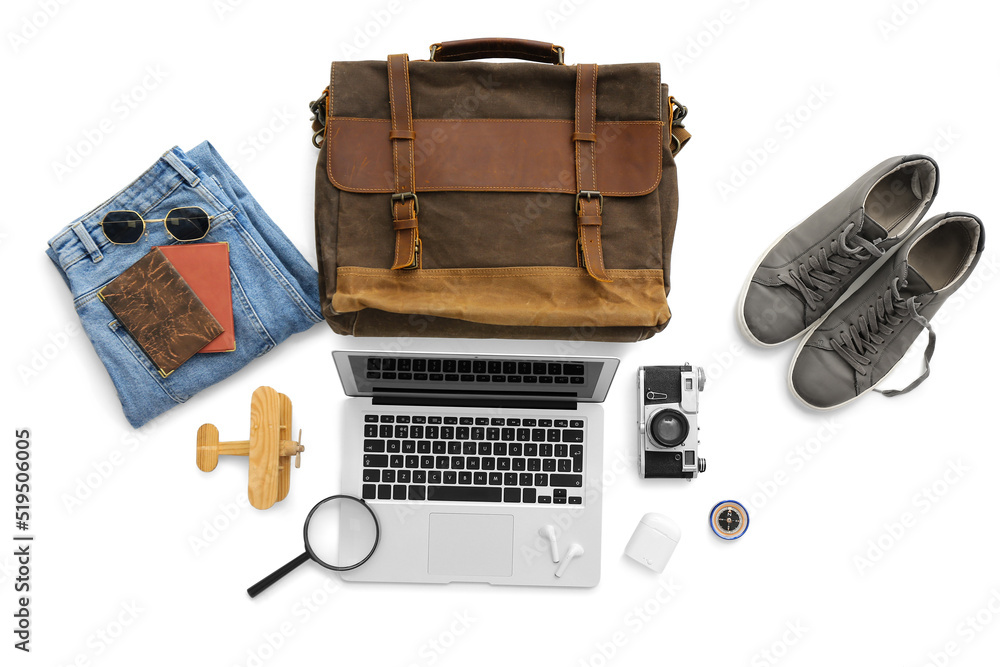 Accessories for travelling with laptop and earphones on white background