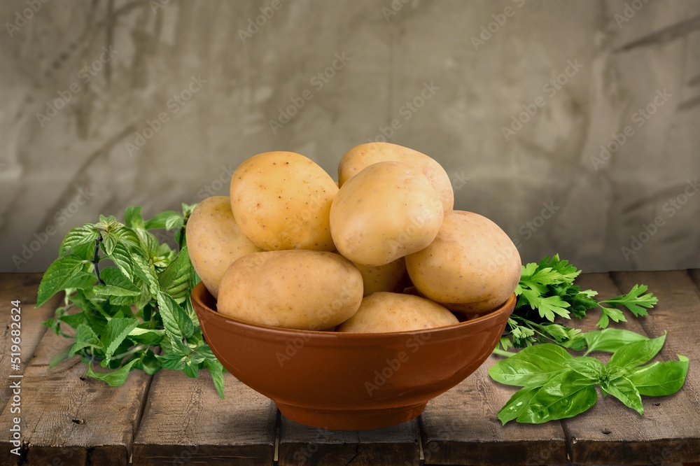 Fresh raw potato in on wooden desk