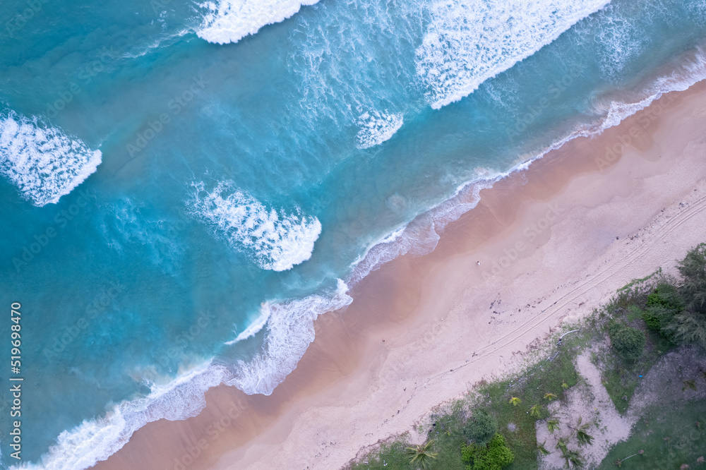 Beach Sand Sea Shore and waves white foamy summer sunny day background.Amazing beach top down view o