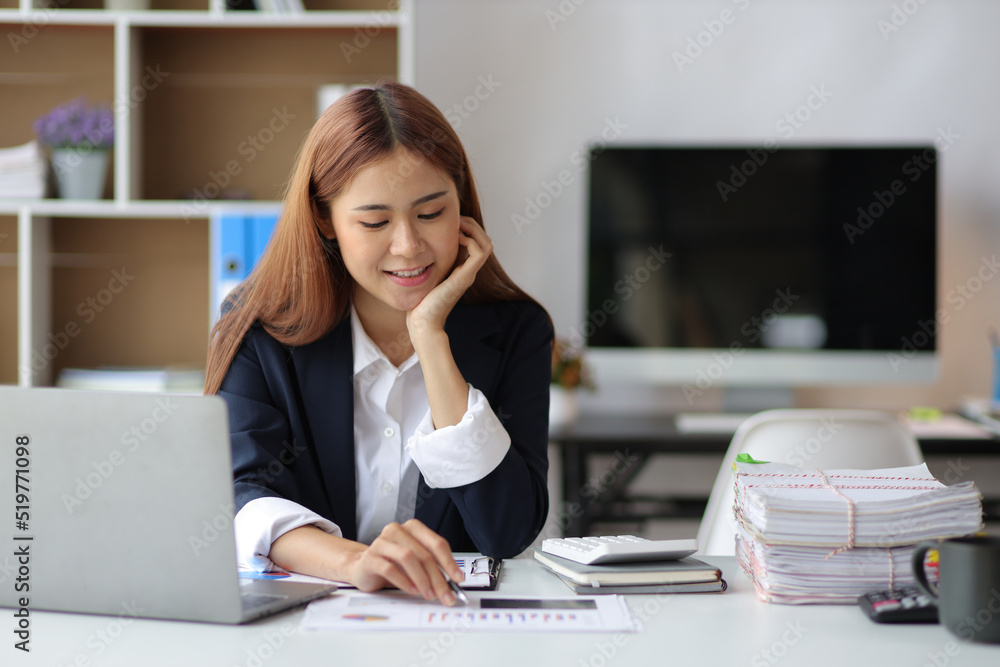 坐在办公桌前分析财务数据和规划投资的商务女性。