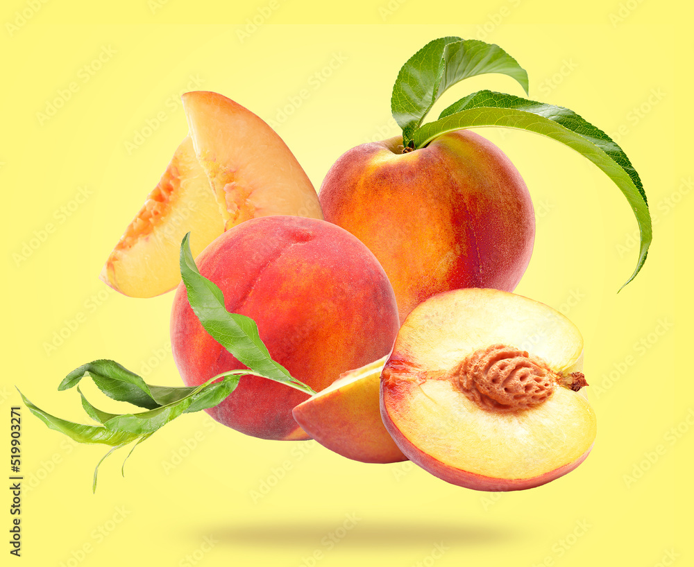 Flying ripe peaches on yellow background