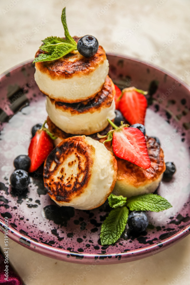 Plate with cottage cheese pancakes, fresh berries and mint leaves, closeup