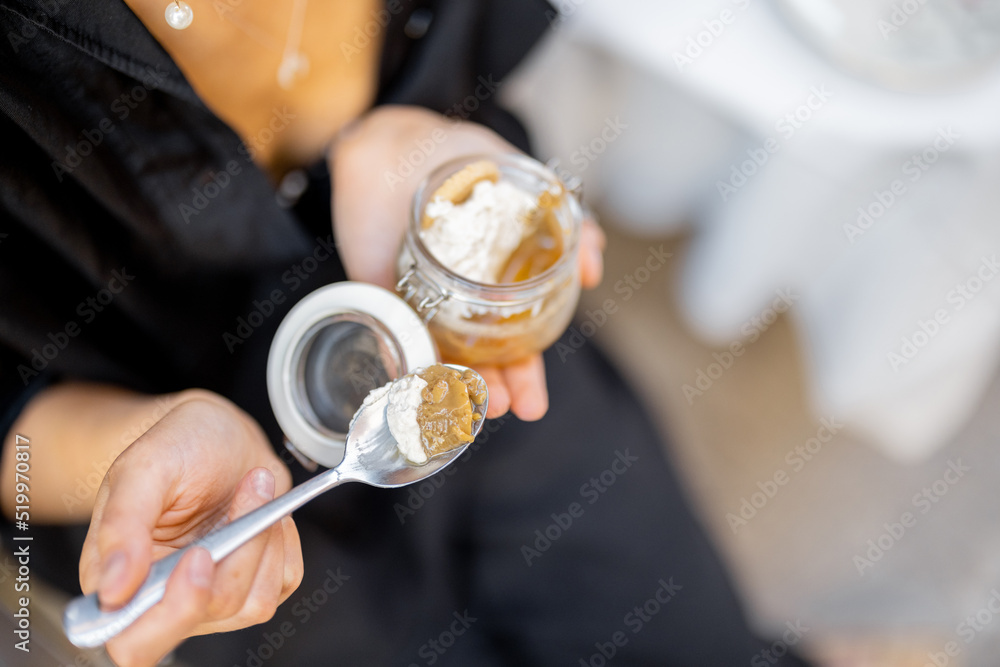 Woman eating tiramisu dessert at the restaurant outdoors. Concept of italian cuisine