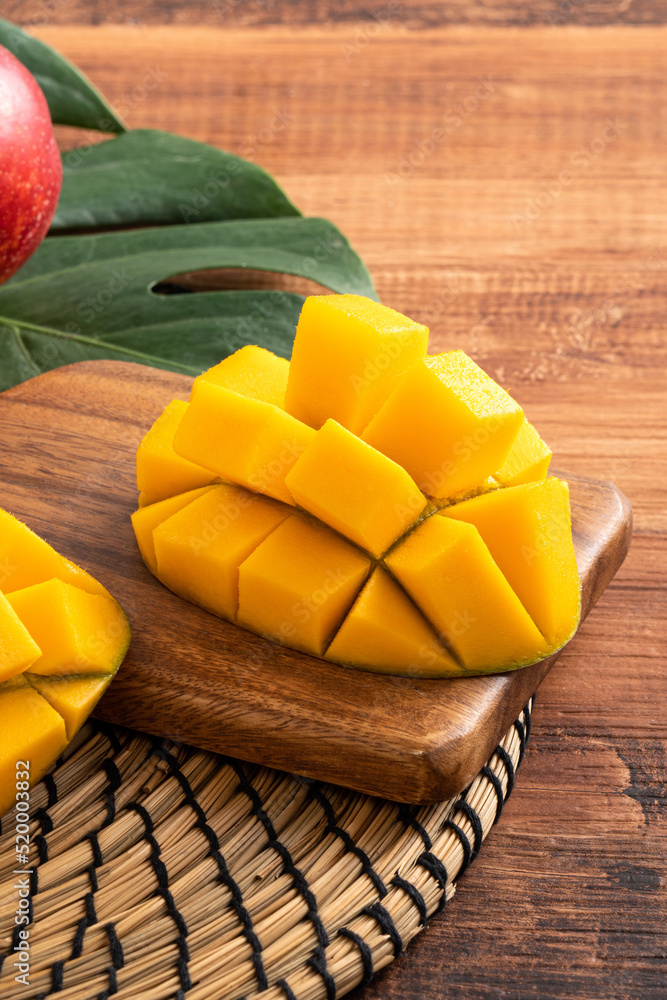 Mango. Fresh mango fruit with leaves over dark wooden table background.