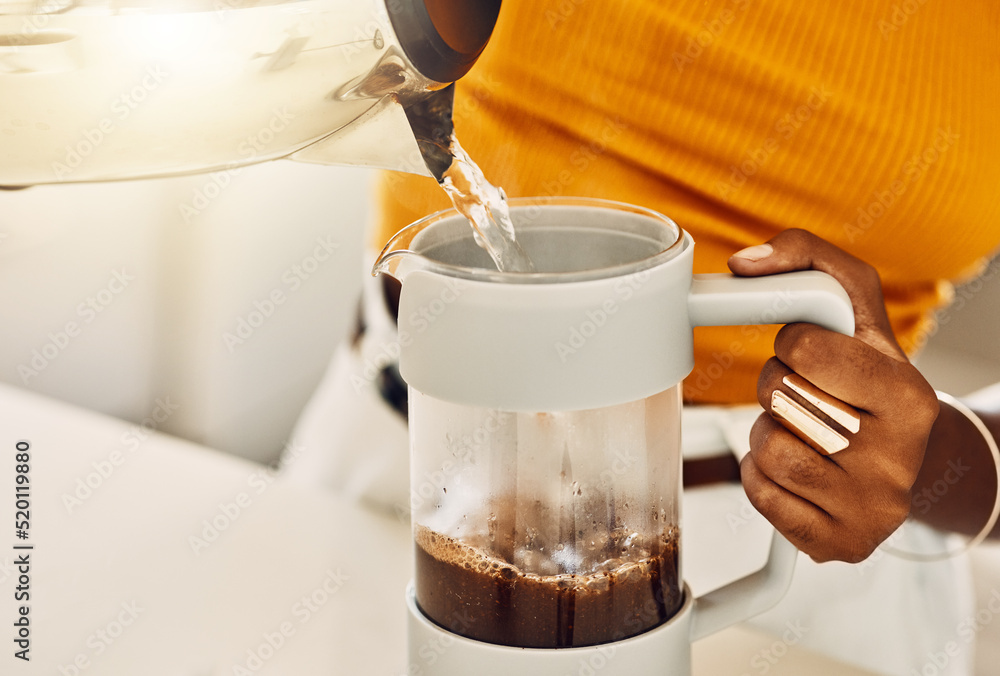 Female hands making morning coffee to enjoy with breakfast, pouring hot water from kettle in a kitch