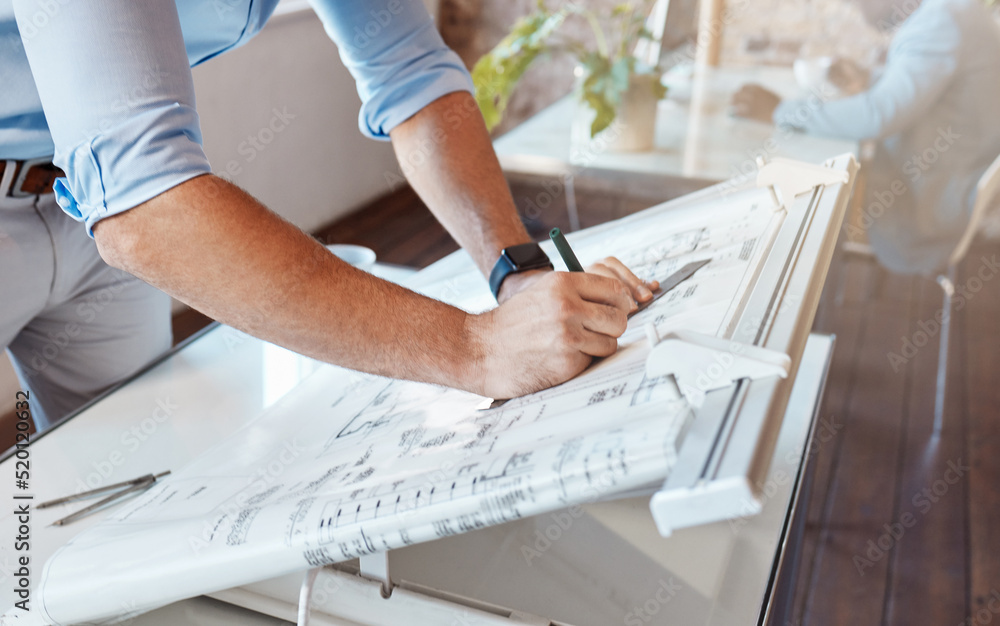 Architect drawing a plan for a building project inside his office. Closeup of a male engineer doing 