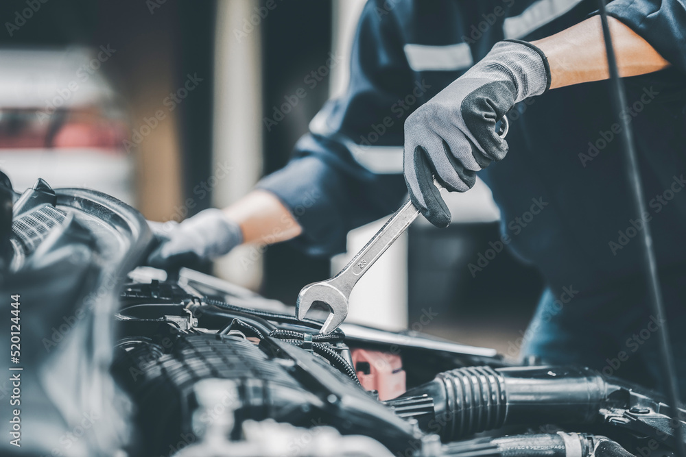 Mechanic works on the engine of the car in the garage. Repair se