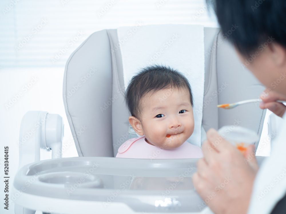 亚洲可爱的小女孩快乐地吃着父母喂养的混合食物