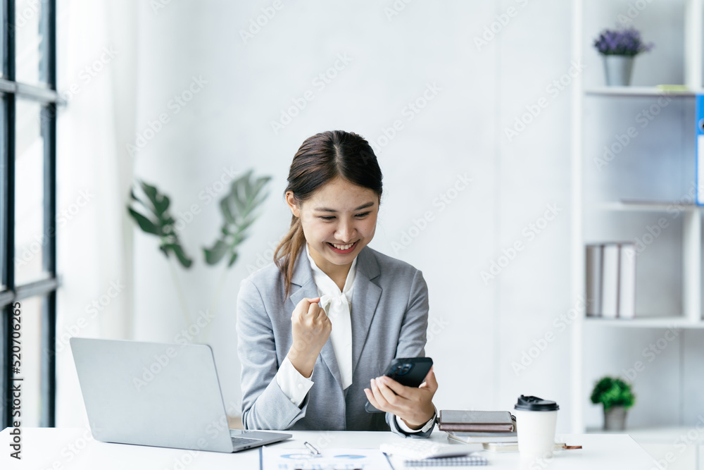 兴奋快乐的商务女性看着手机屏幕，兴高采烈的年轻亚洲女性使用智能手机