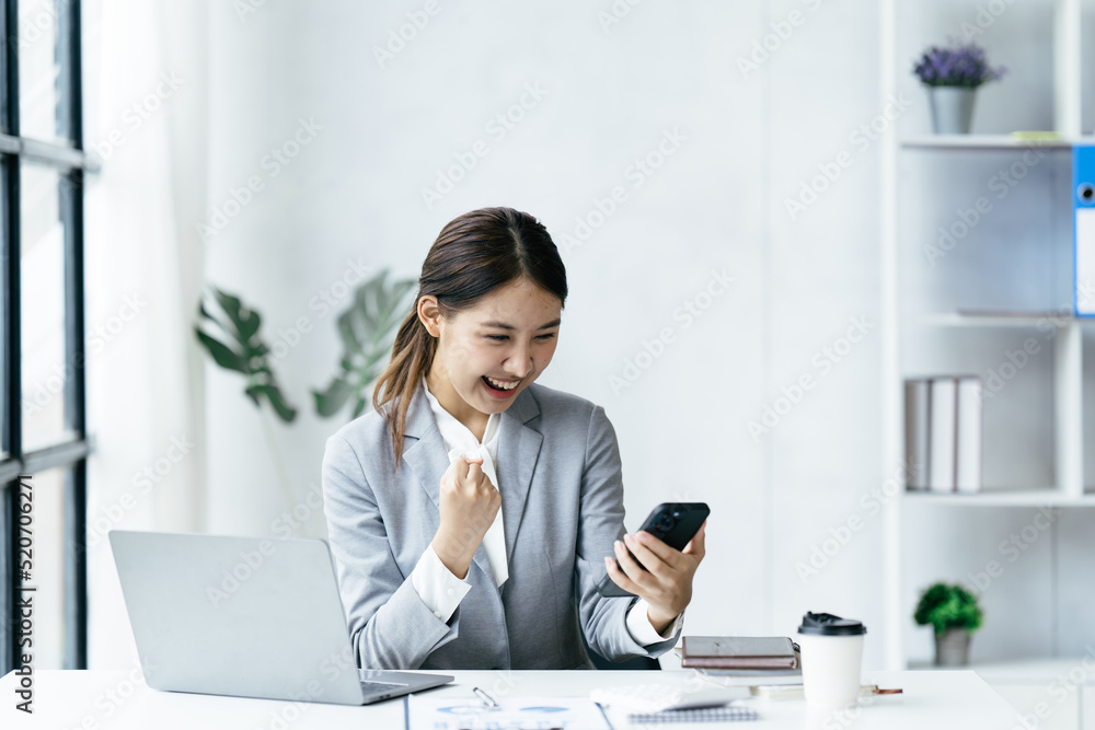 兴奋快乐的商务女性看着手机屏幕，兴高采烈的年轻亚洲女性使用智能手机