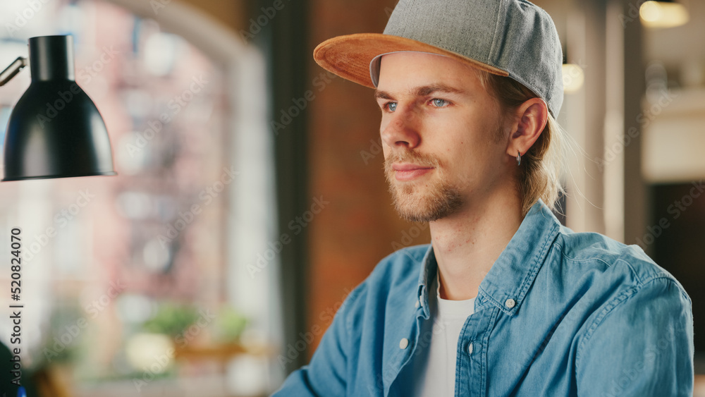 Close Up Portrait of a Man Working on Desktop Computer from Loft Apartment. Creative Male Wearing a 