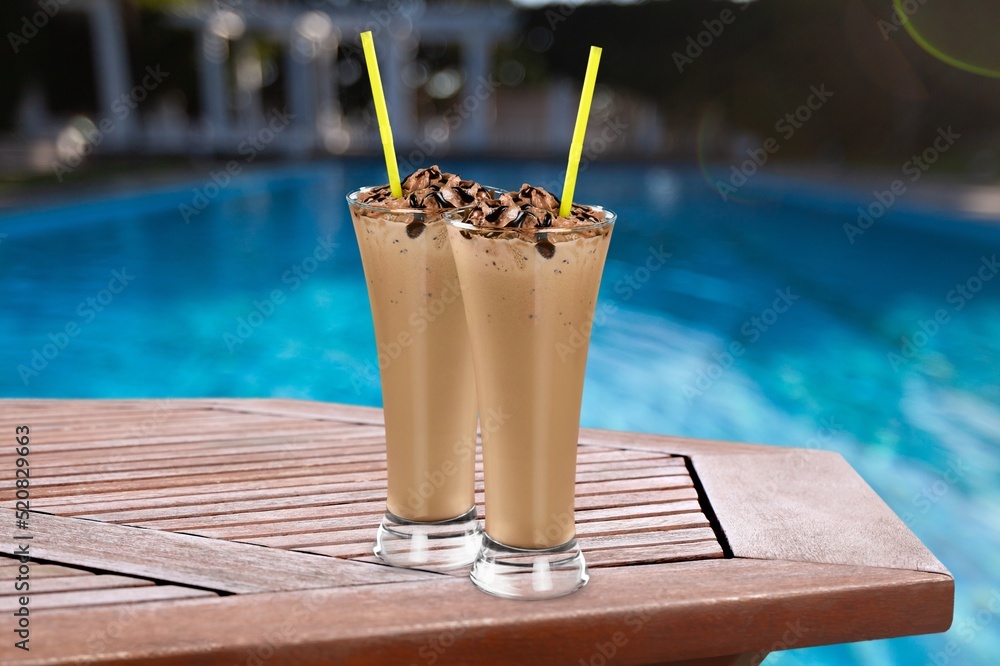 Summer holiday vacation with refreshment drink. Two ice coffee cups behind resort summer pool bar.