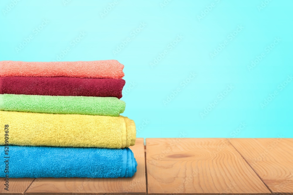 Fresh clean towels on wooden table in bathroom.