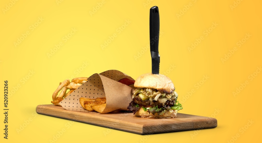 Tasty fresh fast food with French Fries on a wooden board