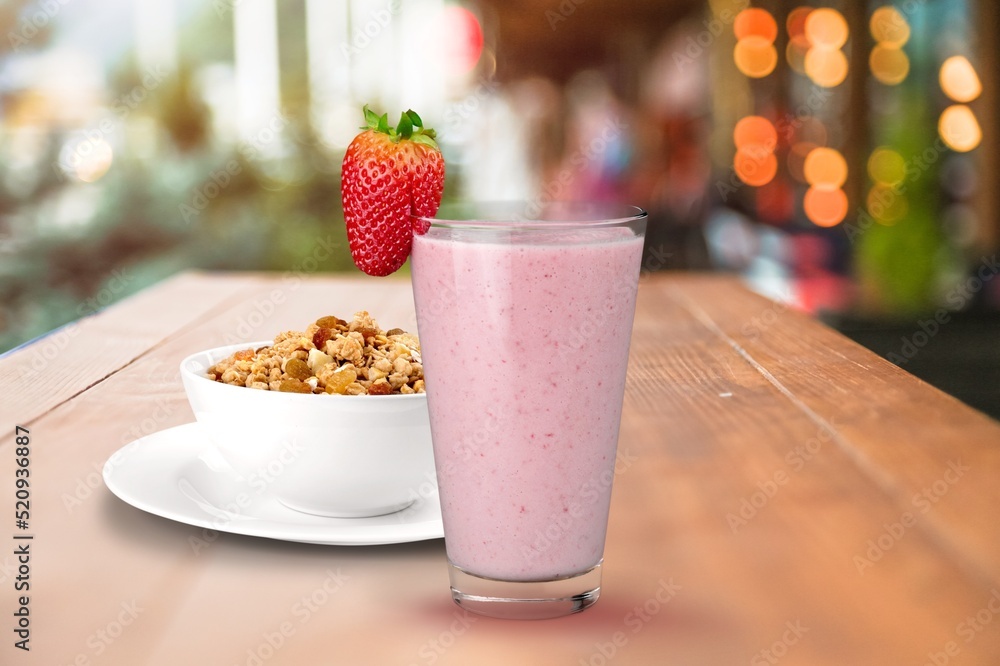 Glass of tasty berry smoothie with oatmeal on kitchen table