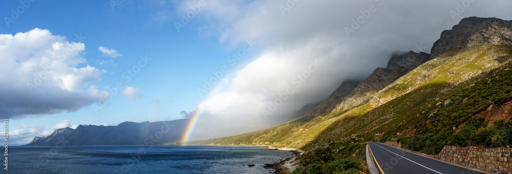 A rainbow and storm over the Kogelberg Mountains along the coastline from Clarence Drive between Gor