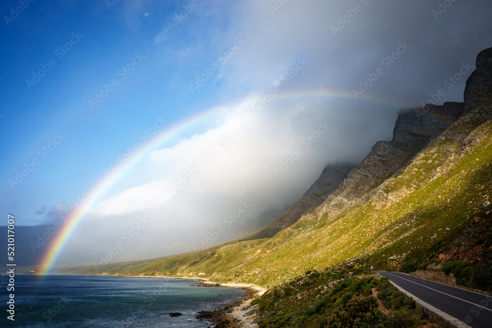 A rainbow and storm over the Kogelberg Mountains along the coastline from Clarence Drive between Gor