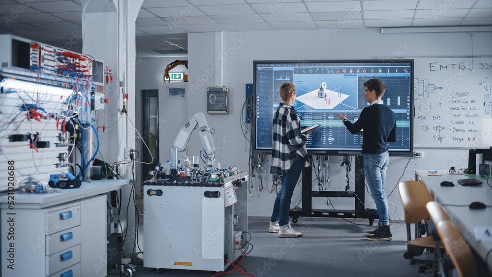 Two Male and Female Students Standing Near Big Screen and Discussing Program for Motion of Robotic A