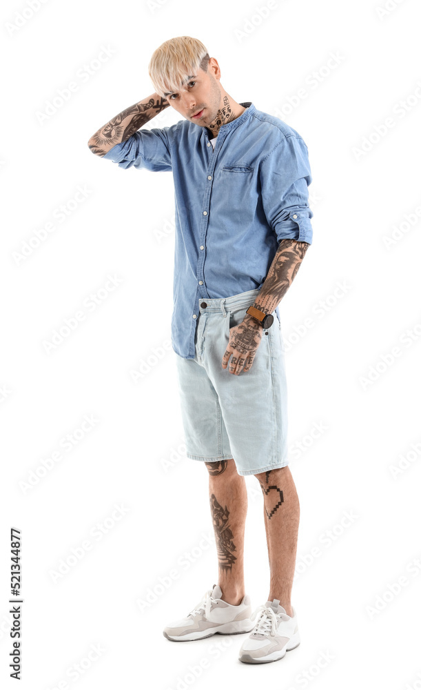 Young tattooed man in denim shirt on white background